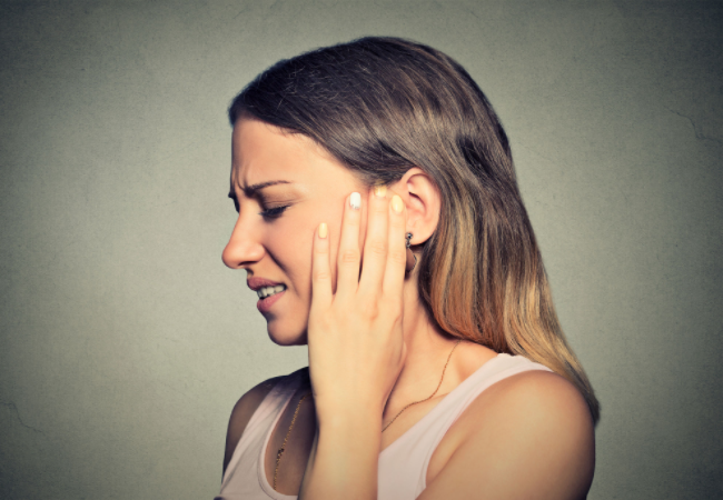 אישה סובלת מטינטון באוזן